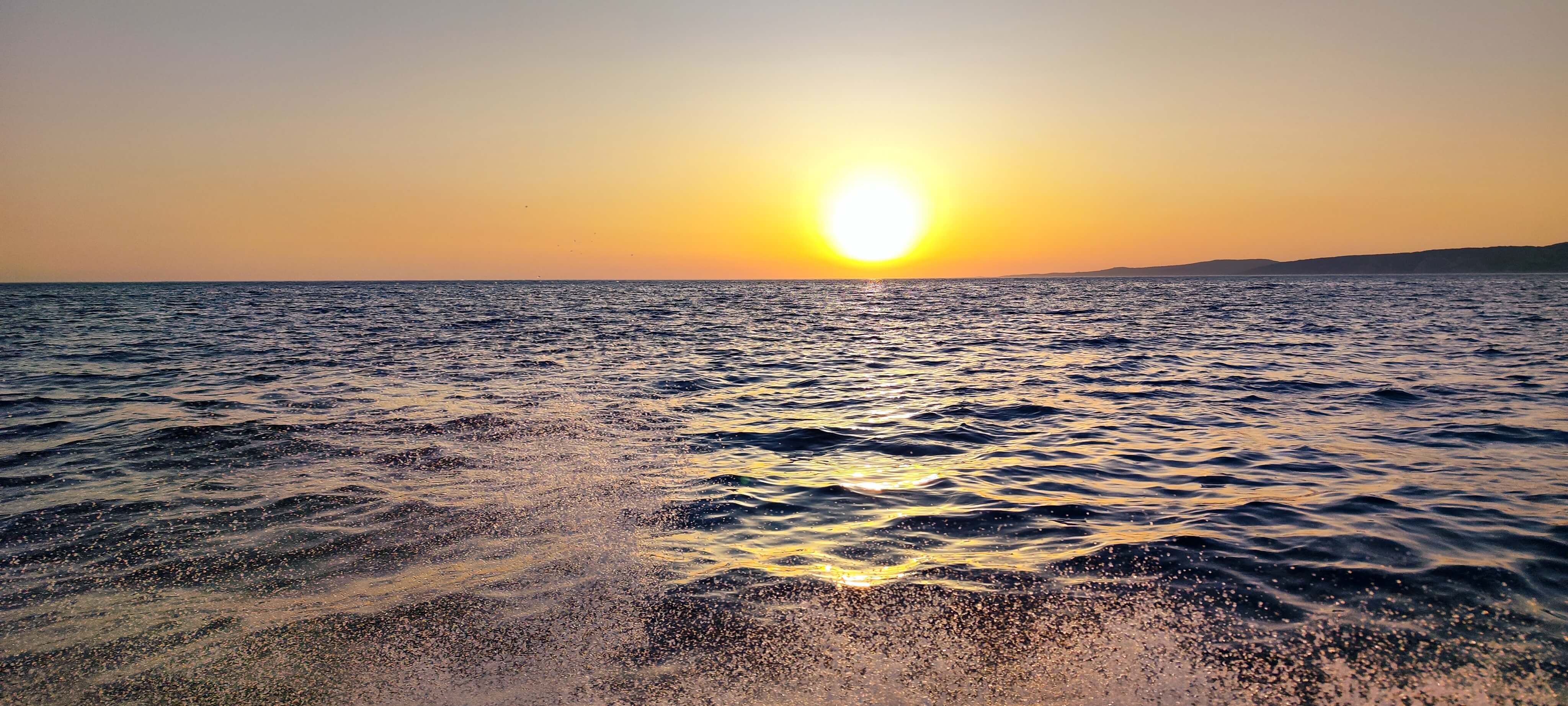 Coucher de soleil sur la mer Adriatique avec lumière dorée sur l'eau et sillage du bateau au premier plan – Avangard Charter excursion coucher de soleil Split Dalmatie Croatie